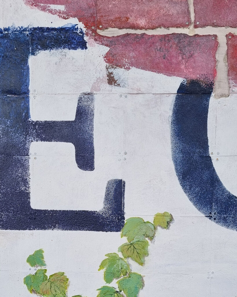 Kunstwerk mit Backsteinfassade von Annett Wagner, verwitterte Aufschrift